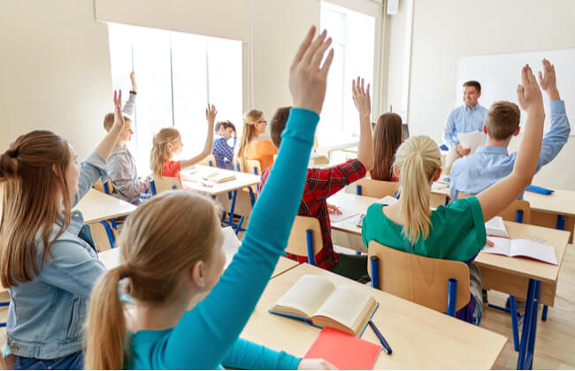 Teacher at public charter school asks question to room full of students.